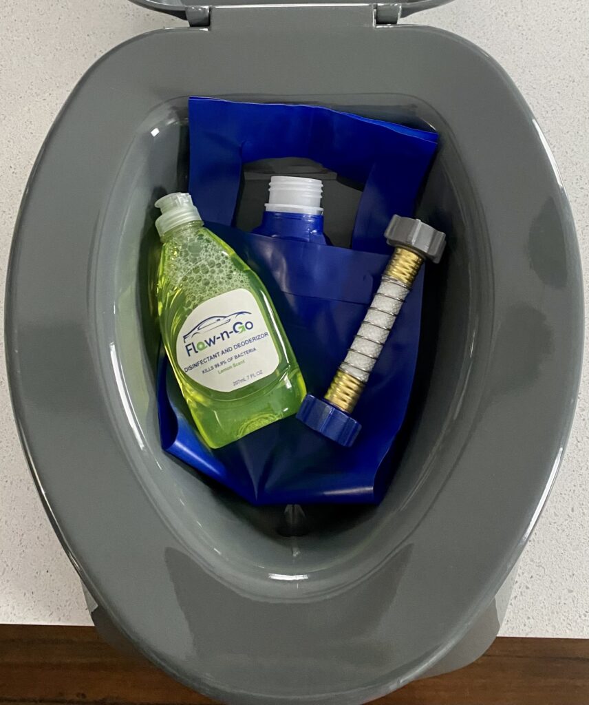 A toilet with soap and a bottle of shampoo.