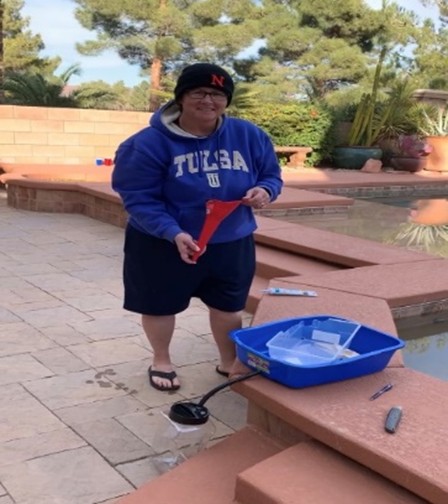A person standing next to some water with a shovel